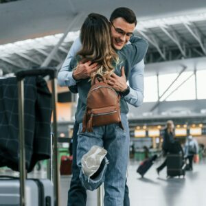 Embracing each other. Young couple is in the airport together