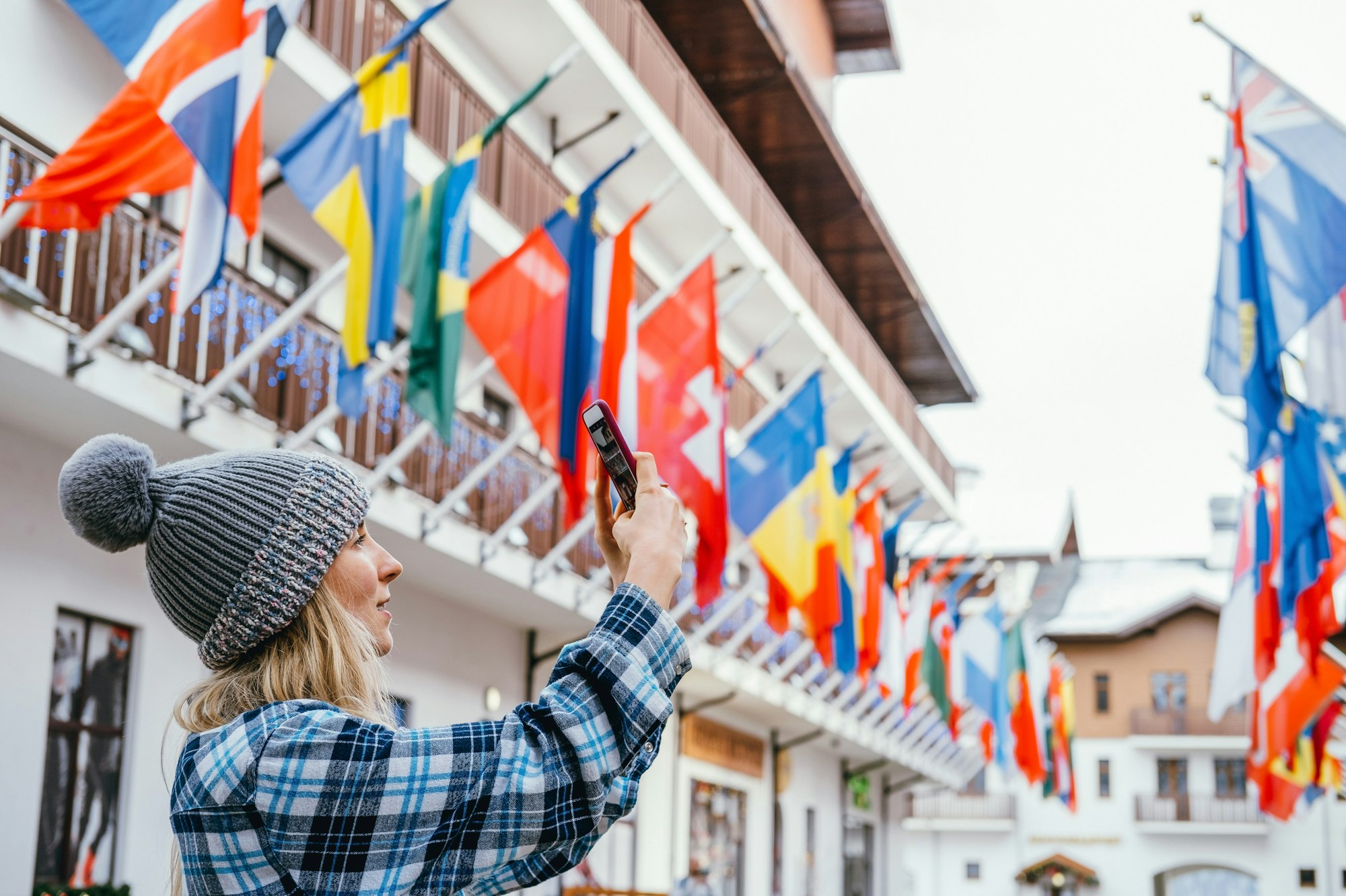 Young woman taking pictures in European travel. Solo travel and using technology concept.